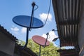 Satellite TV dish antennas installed on the eaves of poor shanty houses in a depressed neighborhood