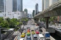 Busy weekday traffic along North Sathon Road, Bangkok, with Chong Nongsi skywalk in background & Silom BTS skytrain line on right