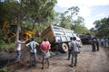Sathyamangalam, Tamil Nadu, India - June 24, 2015: An excavator goes to lift a truck that has gone off the road, people watch on