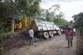 Sathyamangalam, Tamil Nadu, India - June 24, 2015: An excavator goes to lift a truck that has gone off the road, people watch on