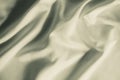 Satin crumpled fabric of light olive color, top view. Natural bed linen, sheets, abstract background of luxury fabric Royalty Free Stock Photo