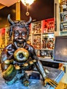 Satire holding an apple in brass on a bar