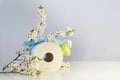 Satirical gift, toilet roll with Easter egg, ribbon and cherry flower twigs, coveted product after shoppers panic buying due to Royalty Free Stock Photo