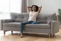 Satisfied African American woman with closed eyes relaxing on couch