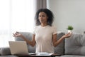 Satisfied African American woman using laptop, meditating at home