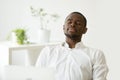 Satisfied African American worker meditating at workplace managi