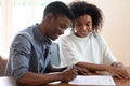 Satisfied African ethnicity couple putting signature on lease agreement Royalty Free Stock Photo