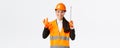 Satisfied asian female construction engineer, architect or inspector at enterprise showing okay gesture and tape measure