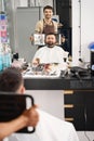 Satisfied barber presenting haircut results to a contented client