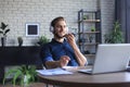 Satisfied business man in glasses holding smartphone near mouth for recording voice message or chatting online Royalty Free Stock Photo