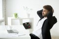 Satisfied businessman relaxing leaning back in chair