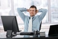 Satisfied businessman smiling at desk