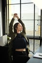 Satisfied businesswoman relaxing on office chair with hands behind her head and looking through window Royalty Free Stock Photo