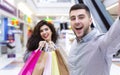 Satisfied couple making selfie after shopping in mall