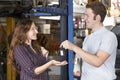 Satisfied Customer Collecting Car From Garage Mechanic