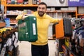 a satisfied customer in a hardware store who purchased a drill and a cordless screwdriver in plastic cases