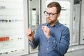 Satisfied Customer. View of happy young male client wearing new glasses, standing near rack and showcase with eyewear Royalty Free Stock Photo