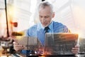 Experienced employer looking at the documents while sitting with his laptop