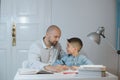 Father and son work together on school homework or homeschooling. Royalty Free Stock Photo