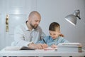 Father and son work together on school homework or homeschooling. Royalty Free Stock Photo