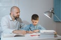 Father and son work together on school homework or homeschooling. Royalty Free Stock Photo