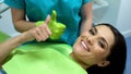 Satisfied female and doctor showing thumb-us after procedure, modern procedures Royalty Free Stock Photo