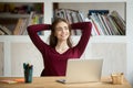 Satisfied female worker leaning in chair after finishing work Royalty Free Stock Photo