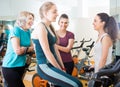 Satisfied females riding stationary bicycles Royalty Free Stock Photo