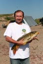 Satisfied fisherman with a big carp. Freshwater sea.