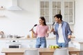 Satisfied funny attractive millennial european couple have fun, singing at imaginary microphone Royalty Free Stock Photo
