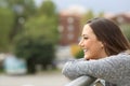 Satisfied girl looking away from a balcony