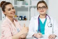 Satisfied happy female patient with medicine doctor at her office