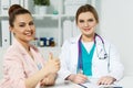 Satisfied happy female patient with medicine doctor at her office