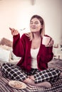 Satisfied happy woman being extremely pleasant with taste of cake