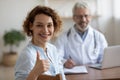 Satisfied healthy woman patient looking at camera showing thumbs up