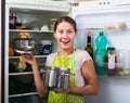 Satisfied housewife near filled fridge