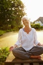 Satisfied with life. an attractive mature woman doing yoga in a beautiful garden setting. Royalty Free Stock Photo