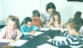 Satisfied little children with teacher drawing in classroom Royalty Free Stock Photo