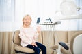 A satisfied little dentist patient showing her perfect smile after treatment in a clinic, waving to the camera Royalty Free Stock Photo