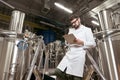 Satisfied man making notes at beer factory