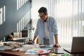 Satisfied with my work. Happy asian man in eyeglasses analyzing new design project and smiling while standing in the Royalty Free Stock Photo