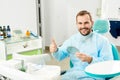 Satisfied patient at dental clinic shows gesture class, good