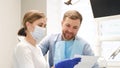Satisfied patient discusses dental treatment plan with female dentist.