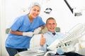 Satisfied patient visiting dentist giving thumbs up Royalty Free Stock Photo