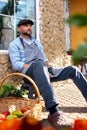 Satisfied and positive man 40-45 years old professional gardener resting after picking vegetables in the garden sits on Royalty Free Stock Photo