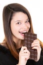 Satisfied pretty girl biting chocolate bar smiling