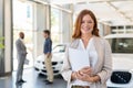 Satisfied saleswoman in car dealership