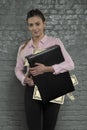 Satisfied secretary holds a briefcase stuffed with money