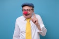 Satisfied senior clown man with red nose showing index fingers up Royalty Free Stock Photo