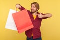 Satisfied shopper, handsome stylish guy in checkered shirt holding shopping bags blank mock up package